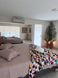 ein Schlafzimmer mit 2 Betten und einer Decke darauf in der Unterkunft Pousada Encantos do Roncador in Barra do Garças