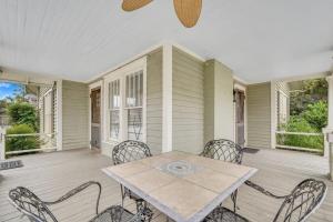 ein Esszimmer mit einem Tisch und Stühlen auf einer Veranda in der Unterkunft Historic Southern Home - close to downtown and GSU in Statesboro