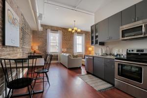 a kitchen and living room with a table and chairs at Downtown Loft- Steps away from Plant Riverside! in Savannah