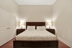 1 dormitorio con 1 cama con 2 mesitas de noche y 2 lámparas en Downtown Loft- Steps away from Plant Riverside!, en Savannah