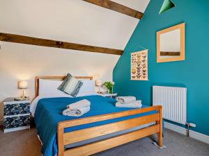 a bedroom with a bed and a blue wall at 4 Bed in Talgarth BN182 in Talgarth