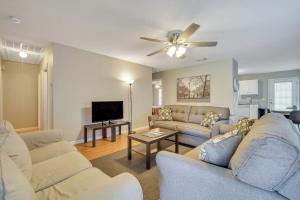 a living room with couches and a flat screen tv at Charming Gray Home- 5 mins from GSU! in Statesboro