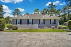 a house with a driveway in front of it at Charming Gray Home- 5 mins from GSU! in Statesboro