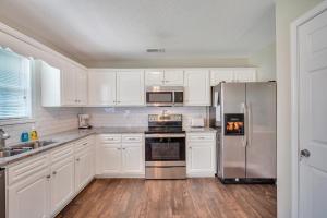 a kitchen with white cabinets and stainless steel appliances at Cozy and Contemporary Villa 1 Mile from GSU in Statesboro