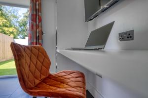 een stoel naast een bureau met een laptop bij Private Ensuite Rooms Coventry in Walsgrave on Sowe
