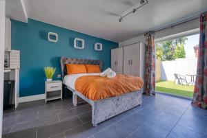 een slaapkamer met een bed en een blauwe muur bij Private Ensuite Rooms Coventry in Walsgrave on Sowe