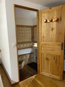 a bathroom with a wooden door and a bath tub at Les Garennes in Saint-Uze