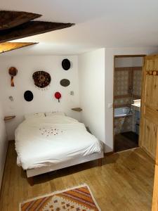 um quarto com uma cama branca com placas pretas na parede em Les Garennes em Saint-Uze