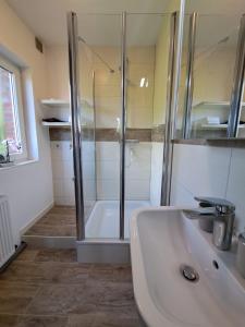 La salle de bains est pourvue d'une douche et d'un lavabo. dans l'établissement Ferienwohnung Butze Esens, à Esens