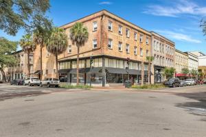 un grand bâtiment en briques au coin d'une rue dans l'établissement Lush Savannah Loft - Near Plant Riverside District, à Savannah