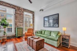 salon z zieloną kanapą i ceglaną ścianą w obiekcie Knockout Loft- Near Plant Riverside w mieście Savannah