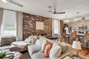 a living room with a couch and a brick wall at The Georgia Peach -near Plant Riverside & downtown in Savannah