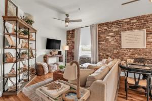 a living room with a brick wall at The Georgia Peach -near Plant Riverside & downtown in Savannah