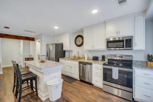 斯泰茨伯勒Eagle Exec Loft In Downtown Statesboro的配有白色橱柜和不锈钢器具的厨房