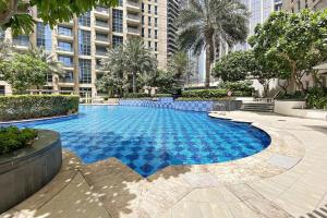 une grande piscine dans une ville avec de grands bâtiments dans l'établissement Silkhaus Burj Khalifa walking distance 1BDR in Downtown, à Dubaï