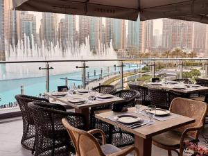 a restaurant with tables and chairs and a fountain at Silkhaus Burj Khalifa walking distance 1BDR in Downtown in Dubai