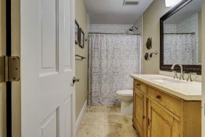 a bathroom with a toilet and a sink and a mirror at Fraser's Folly - Updated Harbour Town Villa in Hilton Head Island