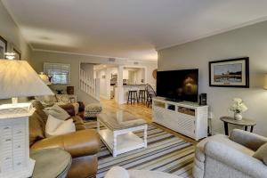 uma sala de estar com um sofá e uma televisão de ecrã plano em Fraser's Folly - Updated Harbour Town Villa em Hilton Head Island