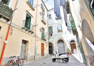 a scooter parked on a street in an alley at La Tata home in Salerno