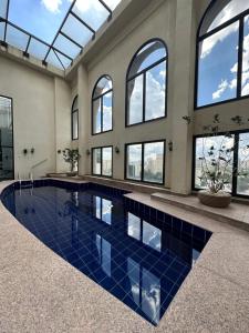 una piscina con piastrelle blu in un edificio con finestre di Clarion Faria Lima a San Paolo