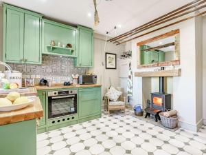 een keuken met groene kasten en een fornuis bij 2 Bed in Richmond 88217 in Barton