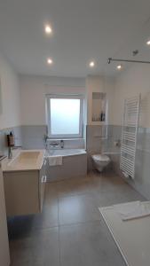Un baño con bañera, lavabo e inodoro. en Dammstraße 24-OG-ZV38, en Salzgitter