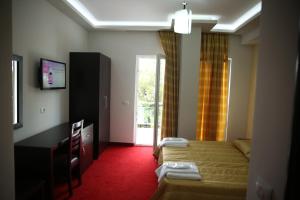 a hotel room with a bed and a television at Hotel Pogradeci in Pogradec