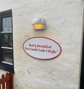 a sign on the side of a building with a light at Bed & Breakfast “Den Gamle Lade I Hejls” in Hejls