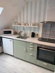 a kitchen with a sink and a stove at Bed & Breakfast “Den Gamle Lade I Hejls” in Hejls