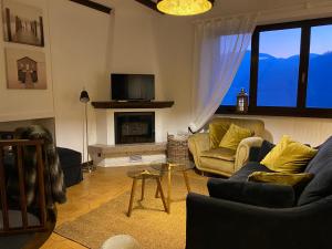 sala de estar con sofá y chimenea en LA PLAYA Cottage con spiaggia privata, en Pettenasco