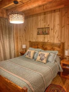 a bedroom with a bed in a room with wooden walls at Casa Encantada HuiloHuilo in Puerto Fuy