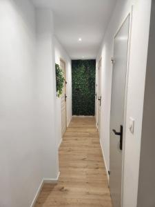 a hallway with white walls and wood floors at Sweet Home in Mulhouse