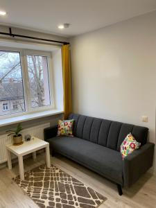 a living room with a couch and a table at Ziemeļblāzma in Rīga