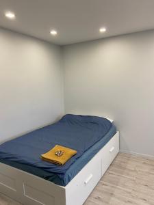 a bedroom with a bed with blue sheets and a yellow blanket at Ziemeļblāzma in Rīga
