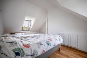 - une chambre avec un lit et une couette à fleurs dans l'établissement Maison équipée proche Paris, à Saint-Ouen