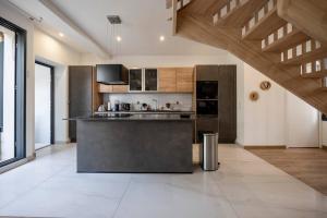 - une grande cuisine avec des appareils en acier inoxydable et des plafonds en bois dans l'établissement Maison équipée proche Paris, à Saint-Ouen