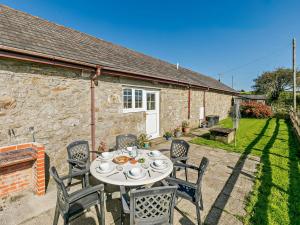 a table and chairs in front of a stone cottage at 3 Bed in Falmouth CONSW in Constantine