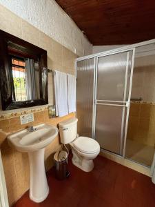 a bathroom with a toilet and a sink and a shower at Finca Hotel Sol Y Luna in Calarcá