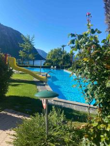 uma piscina com escorrega e um parque infantil em BellaVista Apartment em Bissone