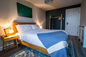 a bedroom with a large bed with a blue and white blanket at Port Aran House in Kilronan +16 photos