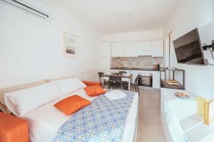 a living room with a white couch and a kitchen at [Suite Marzamemi] – Near Sea in Marzamemi
