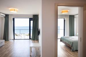 a bedroom with a bed and a view of the ocean at Hotel Bratislava in Shekhvetili