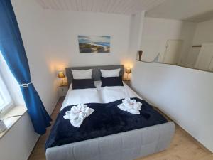 ein Schlafzimmer mit einem Bett mit zwei Handtüchern darauf in der Unterkunft Ferienwohnung Butze Esens in Esens