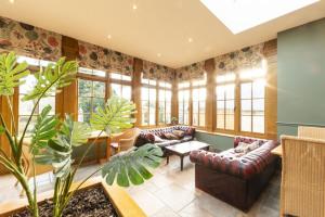 ein Wohnzimmer mit Sofas, einem Tisch und Pflanzen in der Unterkunft The Speech House in Coleford