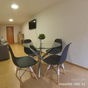 uma mesa de vidro e quatro cadeiras numa sala de estar em Apartamento Calidad - playa - paseos-Servicios em La Garita