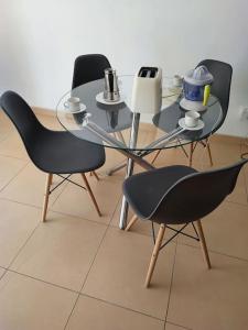 uma mesa de vidro com duas cadeiras e uma mesa com chávenas em Apartamento Calidad - playa - paseos-Servicios em La Garita