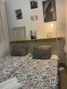 - une chambre avec un lit et une étagère sur le mur dans l'établissement Glass Student-Übica2 Guesthouse, à Mairena del Aljarafe