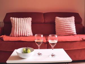 two glasses of wine on a table with a couch at Spacious 1 bed, terrace, garden, Colindale St in Colindale