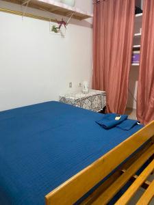 a bedroom with a blue bed and a table at quintal293 in Recife