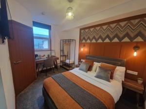 a bedroom with a large bed with a desk and a window at The Coastal Hideaway in Bridlington